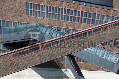 Das größte Übertagegebäude auf Zollverein, die Kohlenwäsche [A14], war zu Betriebszeiten eine Riesenmaschine, die täglich 23.000 Tonnen Rohkohle sortierte und klassierte. Von 2003 bis 2006 wurde sie von dem Office for Metropolitan Architecture (OMA) unter Leitung von Rem Koolhaas und dem Essener Büro Böll & Krabel umfassend saniert. Die Kohlenwäsche ist zentrale Anlaufstelle für Besucher sowie Museumsgebäude des 2010 eröffneten Ruhr Museums und des Portals der Industriekultur. Die oberen Etagen gehören mit den authentisch erhaltenen Übertageanlagen zum Denkmalpfad ZOLLVEREIN®. Auf dem Dach der Kohlenwäsche sind zwei Aussichtsplattformen installiert, die einen Rundblick auf das Gelände und die Region bieten. 

Die beiden 58 Meter langen Rolltreppen an der Kohlenwäsche [A14] befördern die Besucher direkt auf die 24-Meter-Ebene der Kohlenwäsche und von dort wieder nach unten. Die beiden Sonderanfertigungen von ThyssenKrupp Elevator – eine für die Auffahrt, eine für die Abfahrt – orientieren sich an den historischen Bandbrücken. Das Konzept wurde von dem Rotterdamer Office for Metropolitan Architecture (OMA) entwickelt. Eine Fahrt auf einer der beiden höchsten freistehenden Fahrtreppen Deutschlands dauert 90 Sekunden. Highlight: Bei Dunkelheit leuchten die Fahrtreppen orangerot.

Die diagonal und waagerecht zwischen den Gebäuden verlaufenden Bandbrücken sind fester Bestandteil der Gebäudeensembles von Zeche und Kokerei Zollverein. In ihrem Inneren befinden sich Bänder, auf denen die Rohkohle bzw. Kokskohle oder Koks zu den einzelnen Verarbeitungsstufen transportiert wurden. Sie illustrieren sozusagen den Weg der Kohle, neben dem Transportband verlaufen  schmale Wege und Treppe für die Bergleute. Im Gegensatz zu den reinen Mannschaftsbrücken sind die Bandbrücken aus Stahlskelettbauweise mit parallel verlaufenden Fensterbändern geschlossen. 

Ort: Areal A [Schacht XII], Kohlenwäsche [A14]