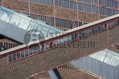Das größte Übertagegebäude auf Zollverein, die Kohlenwäsche [A14], war zu Betriebszeiten eine Riesenmaschine, die täglich 23.000 Tonnen Rohkohle sortierte und klassierte. Von 2003 bis 2006 wurde sie von dem Office for Metropolitan Architecture (OMA) unter Leitung von Rem Koolhaas und dem Essener Büro Böll & Krabel umfassend saniert. Die Kohlenwäsche ist zentrale Anlaufstelle für Besucher sowie Museumsgebäude des 2010 eröffneten Ruhr Museums und des Portals der Industriekultur. Die oberen Etagen gehören mit den authentisch erhaltenen Übertageanlagen zum Denkmalpfad ZOLLVEREIN®. Auf dem Dach der Kohlenwäsche sind zwei Aussichtsplattformen installiert, die einen Rundblick auf das Gelände und die Region bieten. 

Die beiden 58 Meter langen Rolltreppen an der Kohlenwäsche [A14] befördern die Besucher direkt auf die 24-Meter-Ebene der Kohlenwäsche und von dort wieder nach unten. Die beiden Sonderanfertigungen von ThyssenKrupp Elevator – eine für die Auffahrt, eine für die Abfahrt – orientieren sich an den historischen Bandbrücken. Das Konzept wurde von dem Rotterdamer Office for Metropolitan Architecture (OMA) entwickelt. Eine Fahrt auf einer der beiden höchsten freistehenden Fahrtreppen Deutschlands dauert 90 Sekunden. Highlight: Bei Dunkelheit leuchten die Fahrtreppen orangerot.

Die diagonal und waagerecht zwischen den Gebäuden verlaufenden Bandbrücken sind fester Bestandteil der Gebäudeensembles von Zeche und Kokerei Zollverein. In ihrem Inneren befinden sich Bänder, auf denen die Rohkohle bzw. Kokskohle oder Koks zu den einzelnen Verarbeitungsstufen transportiert wurden. Sie illustrieren sozusagen den Weg der Kohle, neben dem Transportband verlaufen  schmale Wege und Treppe für die Bergleute. Im Gegensatz zu den reinen Mannschaftsbrücken sind die Bandbrücken aus Stahlskelettbauweise mit parallel verlaufenden Fensterbändern geschlossen. 

Ort: Areal A [Schacht XII], Kohlenwäsche [A14]
