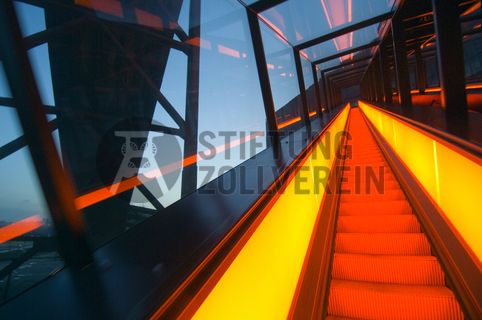 Die beiden 58 Meter langen Rolltreppen an der Kohlenwäsche [A14] befördern die Besucher direkt auf die 24-Meter-Ebene der Kohlenwäsche und von dort wieder nach unten. Die beiden Sonderanfertigungen von ThyssenKrupp Elevator – eine für die Auffahrt, eine für die Abfahrt – orientieren sich an den historischen Bandbrücken. Das Konzept wurde von dem Rotterdamer Office for Metropolitan Architecture (OMA) entwickelt. Eine Fahrt auf einer der beiden höchsten freistehenden Fahrtreppen Deutschlands dauert 90 Sekunden. Highlight: Bei Dunkelheit leuchten die Fahrtreppen orangerot.

Ort: Areal A [Schacht XII], Kohlenwäsche [A14]