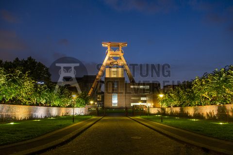 Die Geschichte Zollvereins beginnt in den Pioniertagen des heutigen Ruhrgebiets. Der erste Schacht wurde 1847 abgeteuft, vier Jahre später die erste Kohle gefördert: Vier weitere Anlagen entstanden, die letzte war die Schachtanlage Zollverein XII,  die ab 1932 die Förderung der gesamten Zollverein-Kohle zentral übernahm. 

Die Gebäude der 1928 bis 1932 im Stil der „Neuen Sachlichkeit“ nach Entwürfen der Architekten Fritz Schupp und Martin Kremmer gebauten Anlage sind nach dem Prinzip „Form follows Function“ zum optimalen Ablauf der Kohleförderung und -aufbereitung angeordnet. Trotz Rekordzahlen wie 12.000 Tagestonnen verwertbarer Steinkohle machte das Ende der Schwerindustrie auch vor Zollverein nicht Halt. Am 23. Dezember 1986 fuhr die letzte Schicht ein. An diesem Tag stand die Zeche bereits unter Denkmalschutz, 1990 begannen die Sanierungsarbeiten und seit 2001 sind Zeche und Kokerei Zollverein UNESCO-Welterbe. Mit dem Denkmalpfad ZOLLVEREIN®, dem Ruhr Museum und dem Red Dot Design Museum sind auf Schacht XII drei der beliebtesten Touristenziele der Region angesiedelt. Das Doppelbock-Fördergerüst der Schachtanlage ist heute ein Wahrzeichen für das gesamte Ruhrgebiet. 

Das 55 Meter hohe Doppelbock-Fördergerüst ist das Wahrzeichen der Zeche Zollverein, der Stadt Essen und der gesamten Region: Die als Doppelstrebengerüst in Vollwandbauweise konstruierte Förderanlage ermöglichte eine doppelte Fördermechanik, mittels derer die doppelte Menge Förderwagen bzw. Fördergefäße transportiert werden konnten. Zollverein Schacht XII galt zu Betriebszeiten als die leistungsstärkste Zeche der Welt. 250 Stufen führen auf die oberste Plattform des Gerüstes, deren Seilscheiben sich auch heute noch drehen: Der Schacht wird heute von der RAG AG für die zentrale Wasserhaltung genutzt.

Areal A [Schacht XII], Fördergerüst [A1]