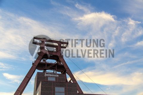 Die Geschichte Zollvereins beginnt in den Pioniertagen des heutigen Ruhrgebiets. Der erste Schacht wurde 1847 abgeteuft, vier Jahre später die erste Kohle gefördert: Vier weitere Anlagen entstanden, die letzte war die Schachtanlage Zollverein XII,  die ab 1932 die Förderung der gesamten Zollverein-Kohle zentral übernahm. 

Die Gebäude der 1928 bis 1932 im Stil der „Neuen Sachlichkeit“ nach Entwürfen der Architekten Fritz Schupp und Martin Kremmer gebauten Anlage sind nach dem Prinzip „Form follows Function“ zum optimalen Ablauf der Kohleförderung und -aufbereitung angeordnet. Trotz Rekordzahlen wie 12.000 Tagestonnen verwertbarer Steinkohle machte das Ende der Schwerindustrie auch vor Zollverein nicht Halt. Am 23. Dezember 1986 fuhr die letzte Schicht ein. An diesem Tag stand die Zeche bereits unter Denkmalschutz, 1990 begannen die Sanierungsarbeiten und seit 2001 sind Zeche und Kokerei Zollverein UNESCO-Welterbe. Mit dem Denkmalpfad ZOLLVEREIN®, dem Ruhr Museum und dem Red Dot Design Museum sind auf Schacht XII drei der beliebtesten Touristenziele der Region angesiedelt. Das Doppelbock-Fördergerüst der Schachtanlage ist heute ein Wahrzeichen für das gesamte Ruhrgebiet. 

Das 55 Meter hohe Doppelbock-Fördergerüst ist das Wahrzeichen der Zeche Zollverein, der Stadt Essen und der gesamten Region: Die als Doppelstrebengerüst in Vollwandbauweise konstruierte Förderanlage ermöglichte eine doppelte Fördermechanik, mittels derer die doppelte Menge Förderwagen bzw. Fördergefäße transportiert werden konnten. Zollverein Schacht XII galt zu Betriebszeiten als die leistungsstärkste Zeche der Welt. 250 Stufen führen auf die oberste Plattform des Gerüstes, deren Seilscheiben sich auch heute noch drehen: Der Schacht wird heute von der RAG AG für die zentrale Wasserhaltung genutzt.

Areal A [Schacht XII], Fördergerüst [A1]