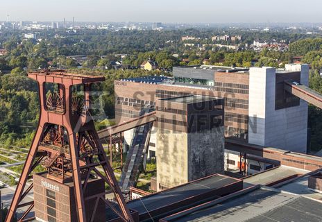 Die Geschichte Zollvereins beginnt in den Pioniertagen des heutigen Ruhrgebiets. Der erste Schacht wurde 1847 abgeteuft, d.h. in die Erde getrieben. Vier Jahre später wurde die erste Kohle gefördert. Im Laufe der Zeit entstanden vier weitere Schachtanlagen. Die letzte war die neue Zentralschachtanlage Zollverein XII, die ab 1932 die gesamte Zollverein-Kohle förderte. 

Noch heute besticht die symmetrische Anordnung der Gebäude auf zwei Blickachsen. Die komplett erhaltenen 20 Einzelgebäude bilden die technischen Arbeits- und Produktionsabläufe nach dem Prinzip „form follows function“ ab. Durchgestaltet bis in die Details der Lampen, Treppengeländer und Türgriffe, ist die Anlage ein komplett erhaltenes Gesamtkunstwerk. Die authentisch erhaltenen Anlagen repräsentieren exemplarisch die soziale, ökonomische, ästhetische und industrielle Geschichte des Kohle- und Stahlzeitalters. 

Trotz Rekordzahlen wie 12.000 Tagestonnen verwertbarer Steinkohle machte das Ende der Schwerindustrie auch vor Zollverein nicht Halt. Am 23. Dezember 1986 fuhr die letzte Schicht ein. An diesem Tag stand die Zeche bereits unter Denkmalschutz, 1990 begannen die Sanierungsarbeiten, seit 2001 sind Zeche und Kokerei Zollverein UNESCO-Welterbe. Mit dem Denkmalpfad ZOLLVEREIN®, dem Ruhr Museum und dem Red Dot Design Museum sind auf Schacht XII drei der beliebtesten Touristenziele der Region. Das Doppelbock-Fördergerüst der Schachtanlage ist heute Wahrzeichen für das gesamte Ruhrgebiet. 

Das 55 Meter hohe Doppelbock-Fördergerüst ist das Wahrzeichen der Zeche Zollverein, der Stadt Essen und der gesamten Region: Die als Doppelstrebengerüst in Vollwandbauweise konstruierte Förderanlage ermöglichte eine doppelte Fördermechanik. Dadurch konnte die doppelte Menge an Förderwagen bzw. Fördergefäßen transportiert werden. Zollverein Schacht XII galt zu Betriebszeiten als die leistungsstärkste Zeche der Welt. 250 Stufen führen auf die oberste Plattform des Gerüstes, deren Seilscheiben sich auch heute noch manchmal drehen: Der Schacht wird von der RAG AG für die zentrale Wasserhaltung genutzt.

Das größte Übertagegebäude auf Zollverein, die Kohlenwäsche [A14], war zu Betriebszeiten eine Riesenmaschine: Täglich wurden dort 23.000 Tonnen Rohkohle sortiert und klassiert. Von 2003 bis 2006 wurde die Kohlenwäsche vom Office for Metropolitan Architecture (OMA) unter Leitung von Rem Koolhaas und dem Essener Büro Böll & Krabel umfassend saniert und für die spätere Nutzung vorbereitet. 

Eine 58 Meter lange Rolltreppe bringt die Besucher heute direkt in das RUHR.VISITORCENTER Essen auf der 24-Meter-Ebene. 2010 eröffnete das Ruhr Museum in der Kohlenwäsche, das in drei Etagen eine Dauerausstellung zu den Kategorien Gegenwart – Gedächtnis – Geschichte präsentiert. Die oberen Etagen gehören mit den authentisch erhaltenen Übertageanlagen zum Denkmalpfad ZOLLVEREIN®. Auf dem Dach der Kohlenwäsche sind zwei Aussichtsplattformen installiert, die einen Rundblick auf das Gelände und die Region bieten. Das Portal der Industriekultur informiert über industriekulturelle Angebote im Ruhrgebiet und in Nordrhein-Westfalen.

Areal A [Schacht XII]